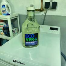 Waschmittel für schwarze Wäsche von Ecover steht auf einer Waschmaschine.