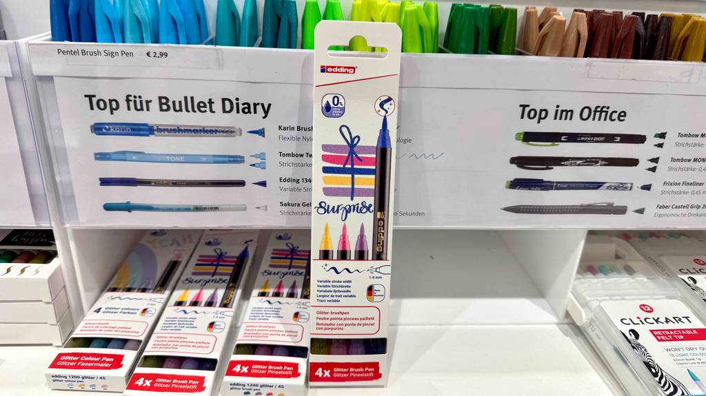 Getestet: Die Pinselstifte in der Vierer-Packung lehnen an einem weißen Regal mit einzelnen bunten Stiften.