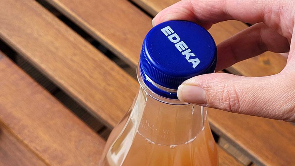 Im Test: Nahaufnahme wie eine Hand den Deckel einer Flasche Rhabarbersaft aufschraubt.
