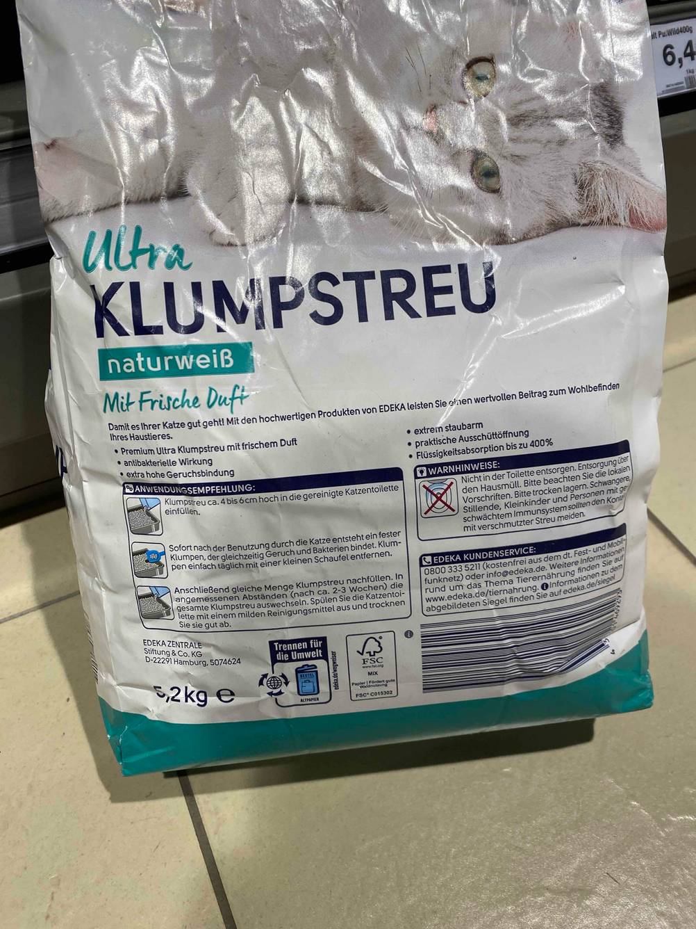 Katzenstreu-Test: Rückseite einer Packung auf einem Fließenboden.