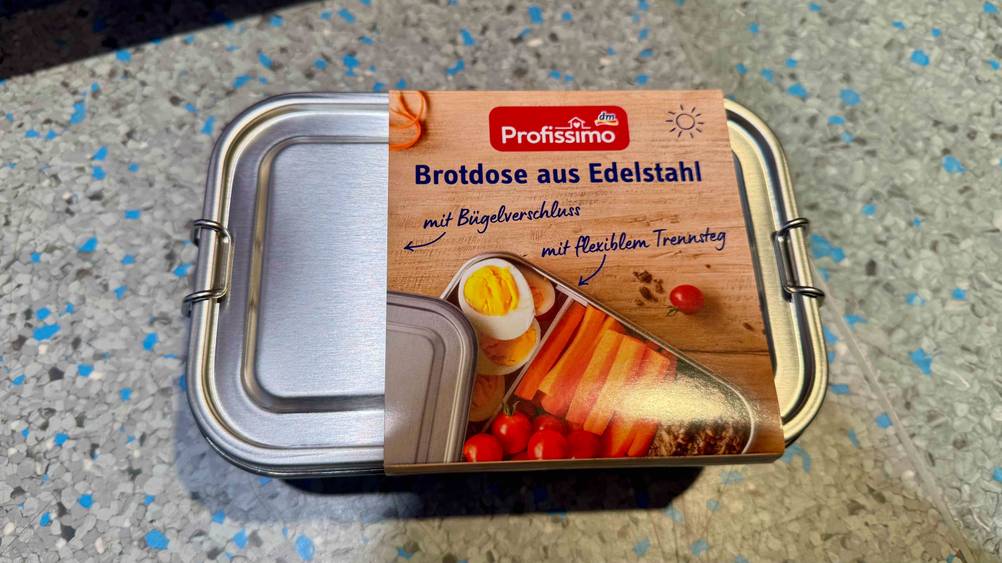 Edelstahl-Brotdose im Test: Eine Dose von oben auf einem grau-blauen Boden.