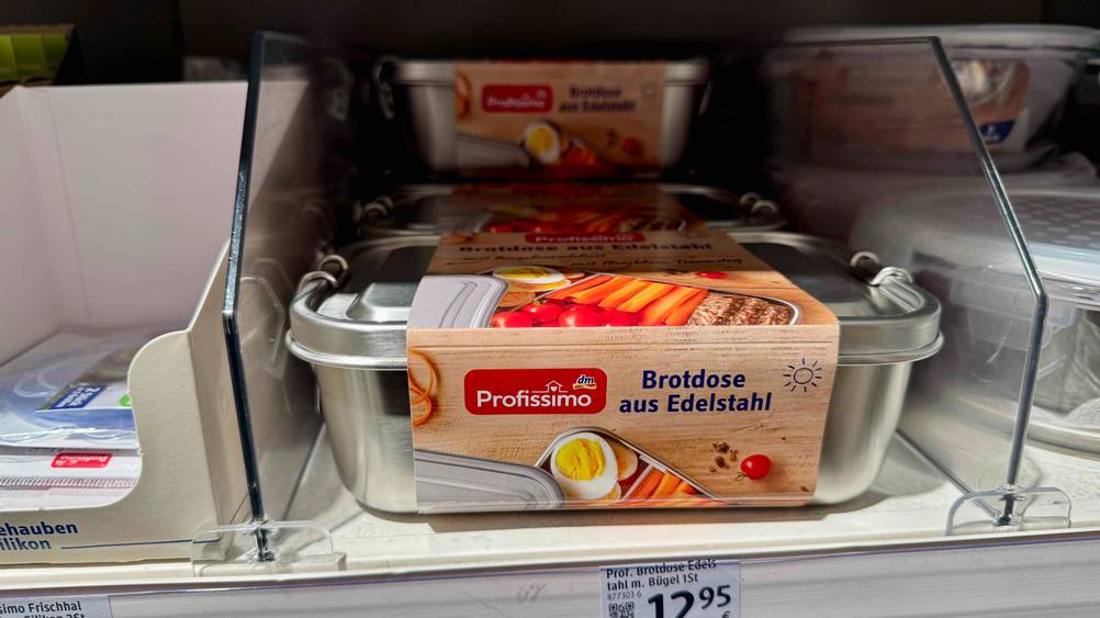 In einem Regal befinden sich mehrere getestete Edelstahl-Brotdosen mit Preisangaben.