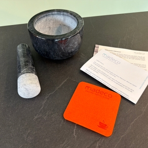 Der Lieferumfang vom Madeco-Edler-Marmor-Mörser steht auf einer Arbeitsplatte.