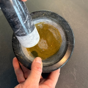 Zerkleinerte Kräuter im Madeco-Edler-Marmor-Mörser.