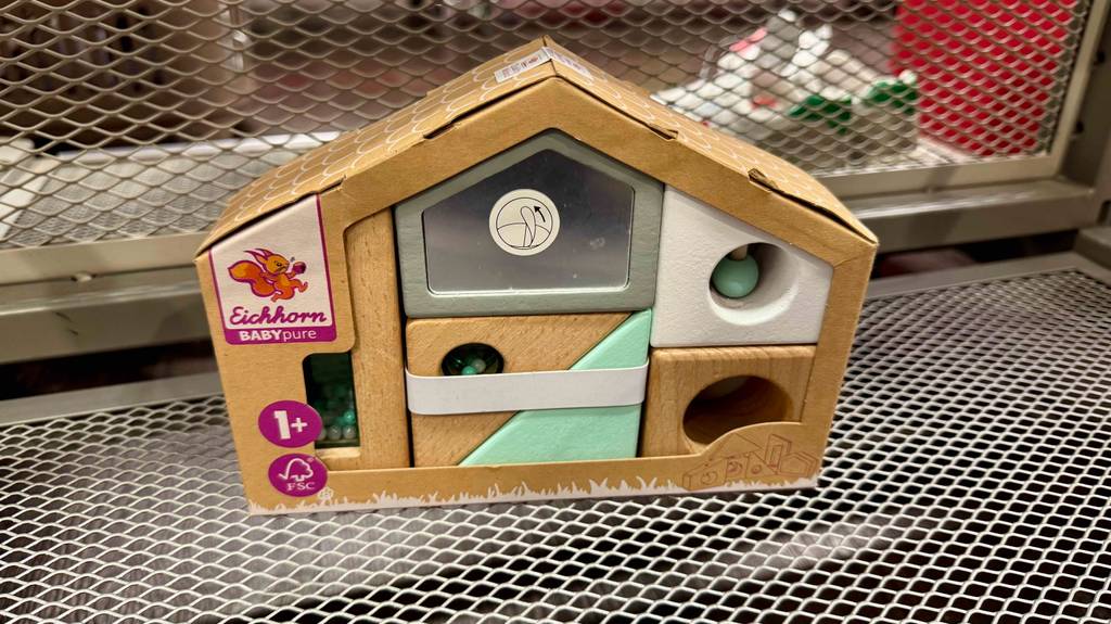 Blick von schräg oben auf ein getestetes Holzspielzeug für das Baby in Form eines Hauses.