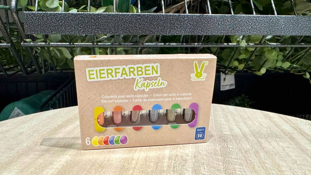 Auf einem Holztisch steht eine Packung der Eierfarben im Test.