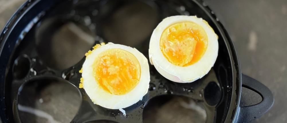 Ein halbiertes Ei liegt auf der Eierschale des getesteten Eierkochers von Russell Hobbs.