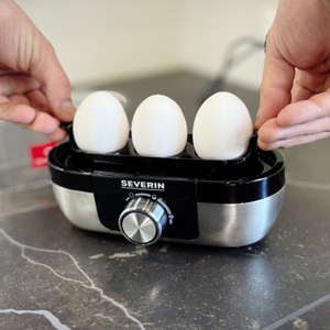 Eierkocher-Test: Eine Person nimmt den Eierhalter mit drei Eiern aus dem Severin-Eierkocher.