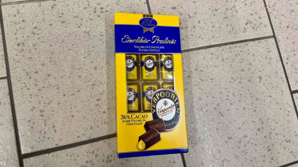 Auf einem Fließenboden liegt eine Packung der Eierlikör-Pralinen im Test.