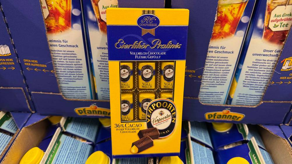 Eierlikör-Pralinen im Test: Eine Packung steht vor mehreren Getränkepackungen.
