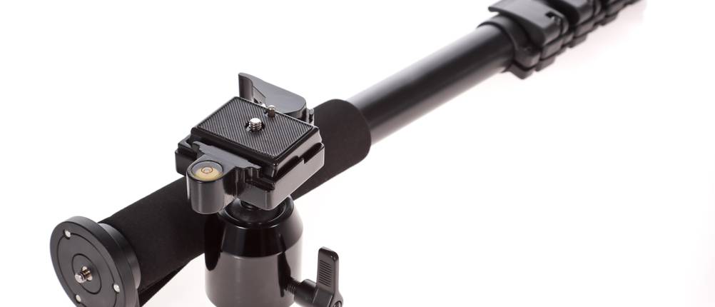 Ein Einbeinstativ im Test: Schwarz, liegend auf weißem Grund.