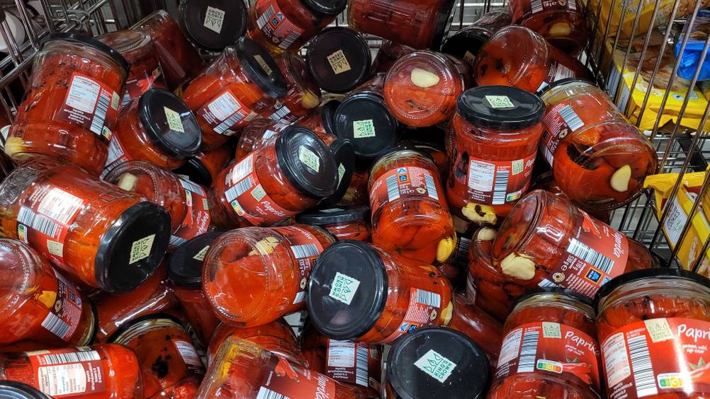 Mehrere Gläser der eingelegten Paprika im Test in einem Gitterkorb.