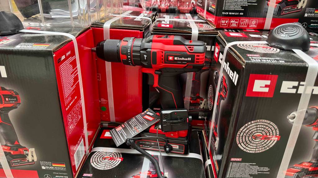 Im Test: Ein Einhell-Akku-Schlagbohrschrauber steht zwischen mehreren verpackten Geräten.