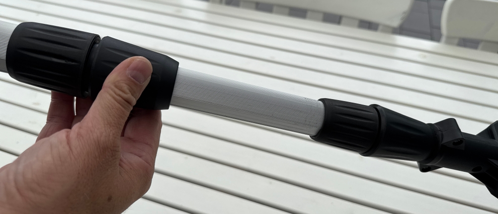 Eine Hand schraubt eine Schraube zur Verlängerung der Einhell-Akku-Teleskop-Heckenschere GE-HH fest