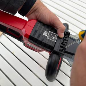 Eine Hand schraubt den Griff an die Einhell ARCURRA 18/55