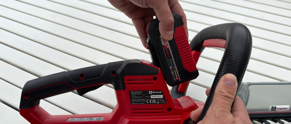 Eine Hand schiebt den Akku auf die Einhell ARCURRA 18/55