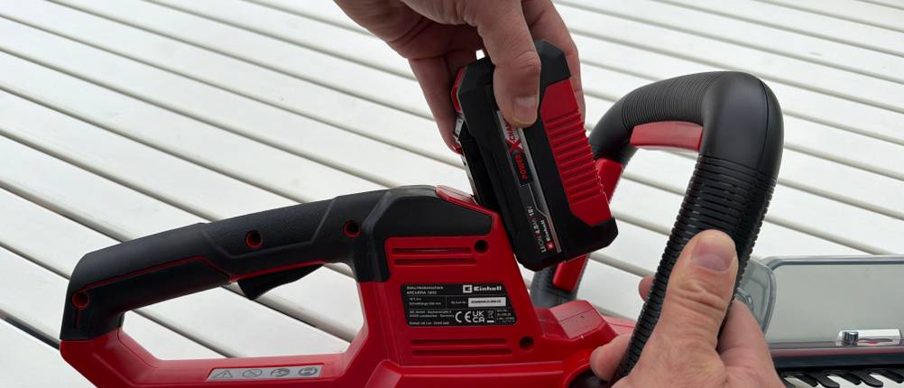 Eine Hand schiebt den Akku auf die Einhell ARCURRA 18/55
