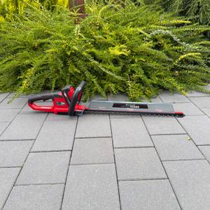 Die Einhell ARCURRA 18/55 liegt auf einem gepflasterten Boden