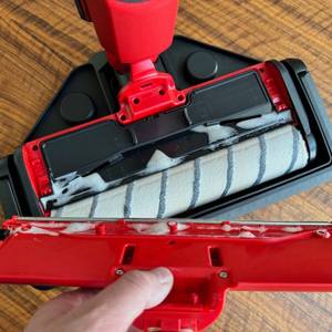 Eine Hand hält eine Abdeckung des Einhell CLEANEXXO neben diesen