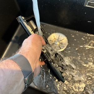 Eine Hand wäscht einen Teil des Einhell CLEANEXXO ab