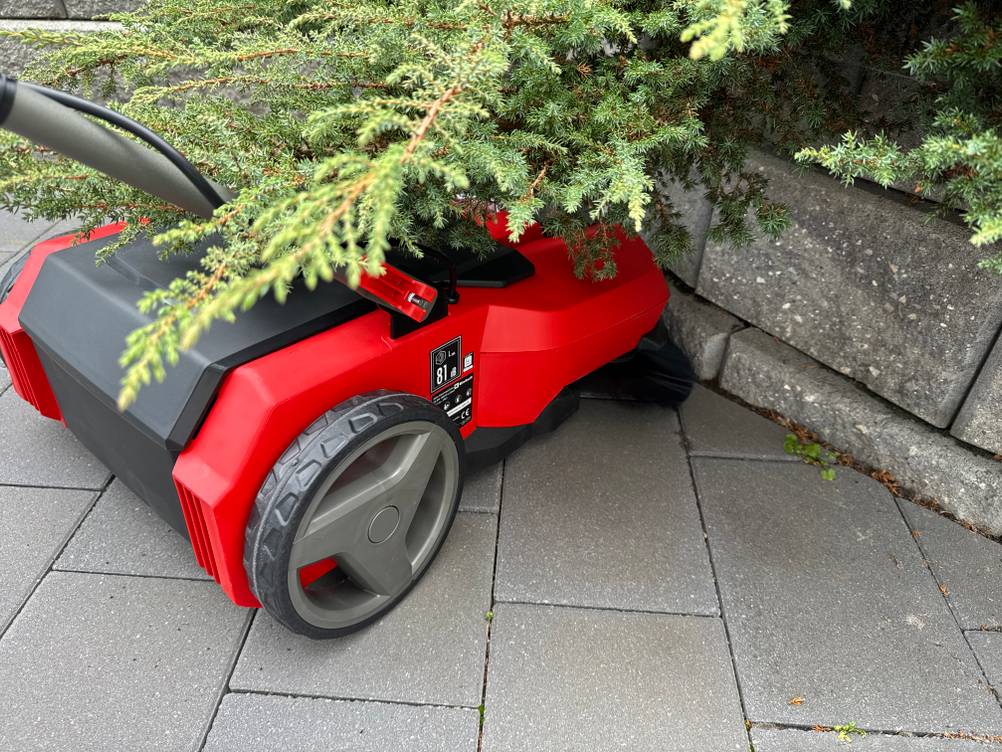 Mit der Einhell E-SW 18/610 wird unter einem Gebüsch gepflasterter Boden gereinigt.