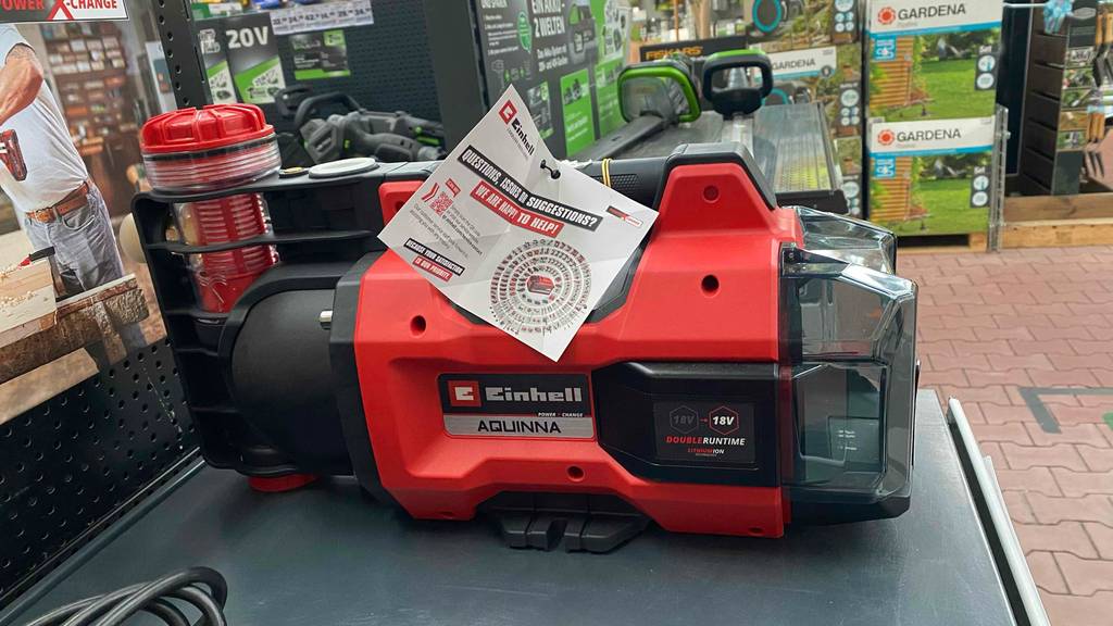 Einhell-Gartenpumpe im Test: eine rote Einhell-Gartenpumpe Aquina steht in einem Verkaufsbereich.