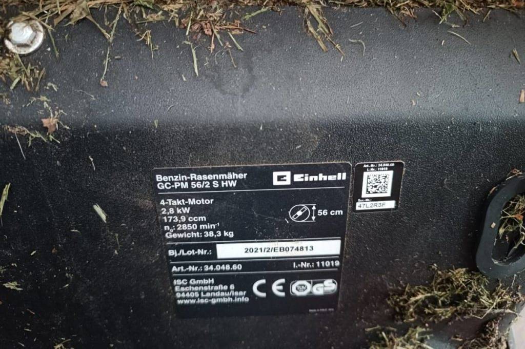 Detailansicht einer schwarzen Produkt-Plakette mit Geräte-Nummer und Leistungsangaben in Weiß auf einem Bauteil des getesteten Benzin-Rasenmähers von Einhell.