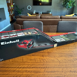 Der Karton der Einhell GE-EH 7067 liegt auf einem Holztisch.