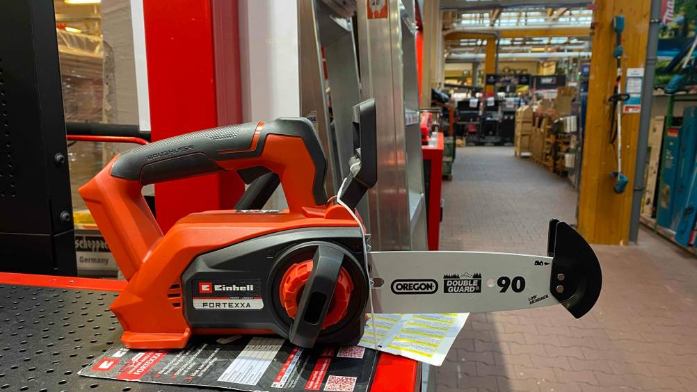 Im Test: Eine Kettensäge von der Seite in einem Baumarkt auf einer dunklen Fläche stehend.