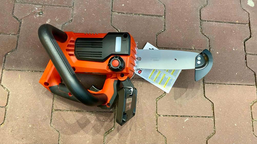 Eine getestete Kettensäge auf der Seite liegend mit Griff nach oben auf einem Steinboden.