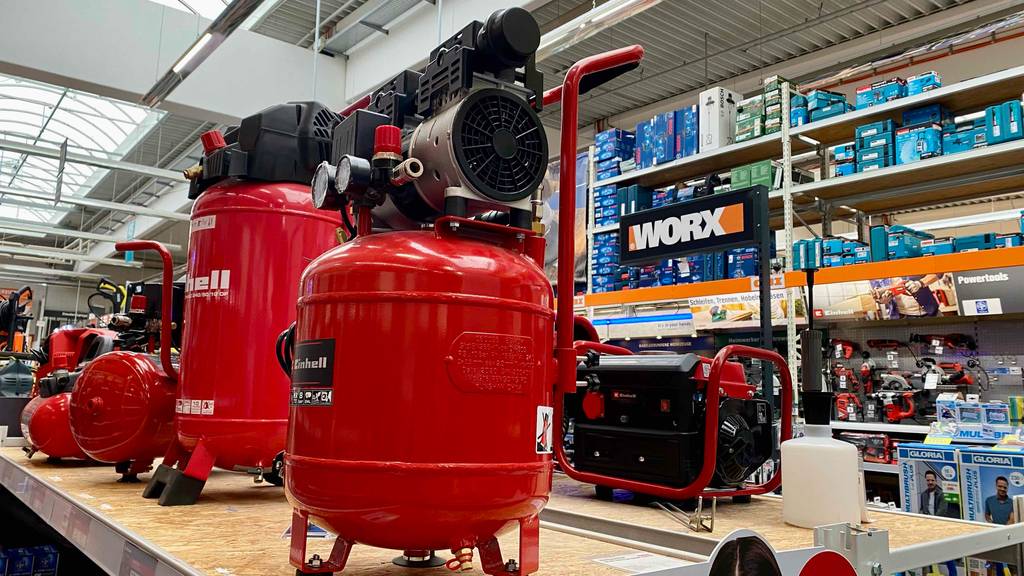 Einhell-Kompressor getestet: Ein Gerät von schräg unten in einer Verkaufsfläche, im Hintergrund andere Produkte.