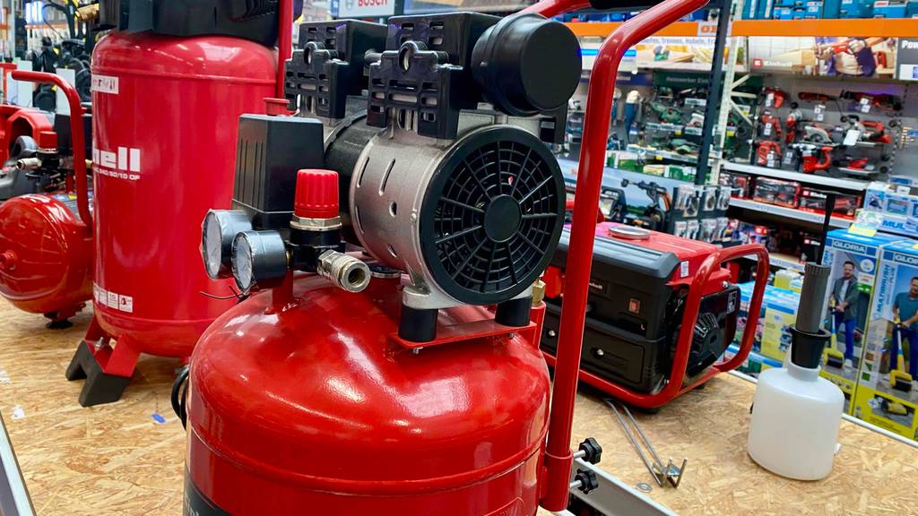 Nahaufnahme des Motors eines getesteten Einhell-Kompressors in einer Verkaufsfläche neben anderen Produkten.