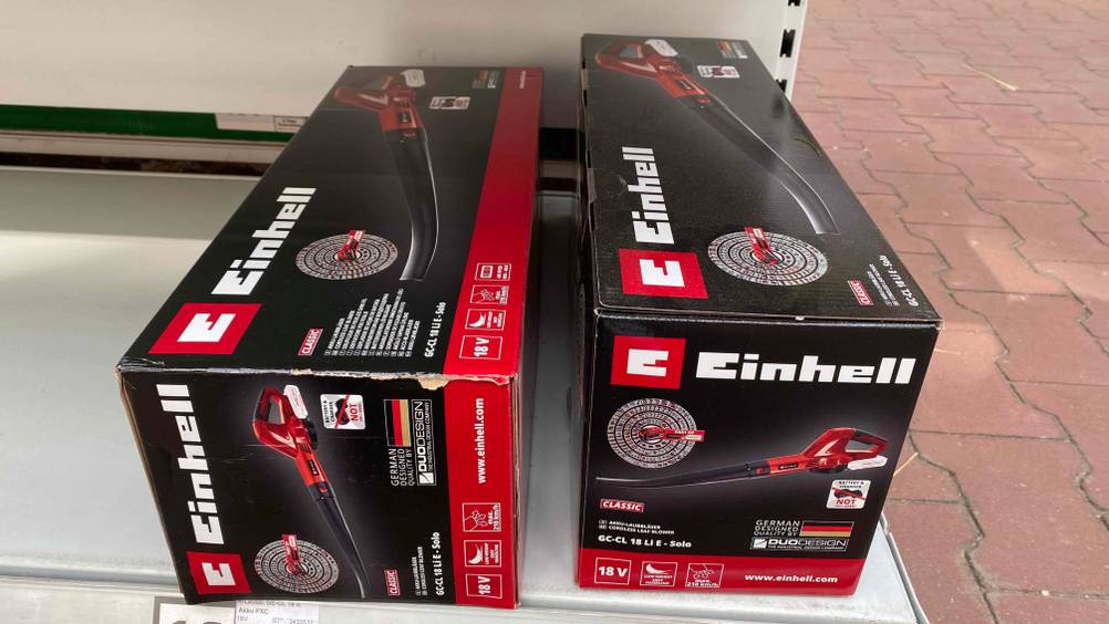 Zwei originalverpackte Einhell-Laubbläser im Test liegen in einem Regal.