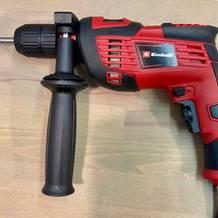 Die Einhell TC-ID 720/1 E vollständig aufgebaut mit montiertem Griff und Bohrer. Das Gerät liegt auf einer hellen Holzfläche.