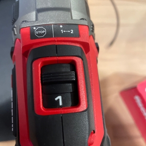 Der Gangwahlschalter des Einhell Professional Akku-Schlagbohrschraubers ist aus der Nähe fotografiert. Die Stufe „1“ ist deutlich markiert, daneben befinden sich ein STOP-Zeichen und ein Umschalter.