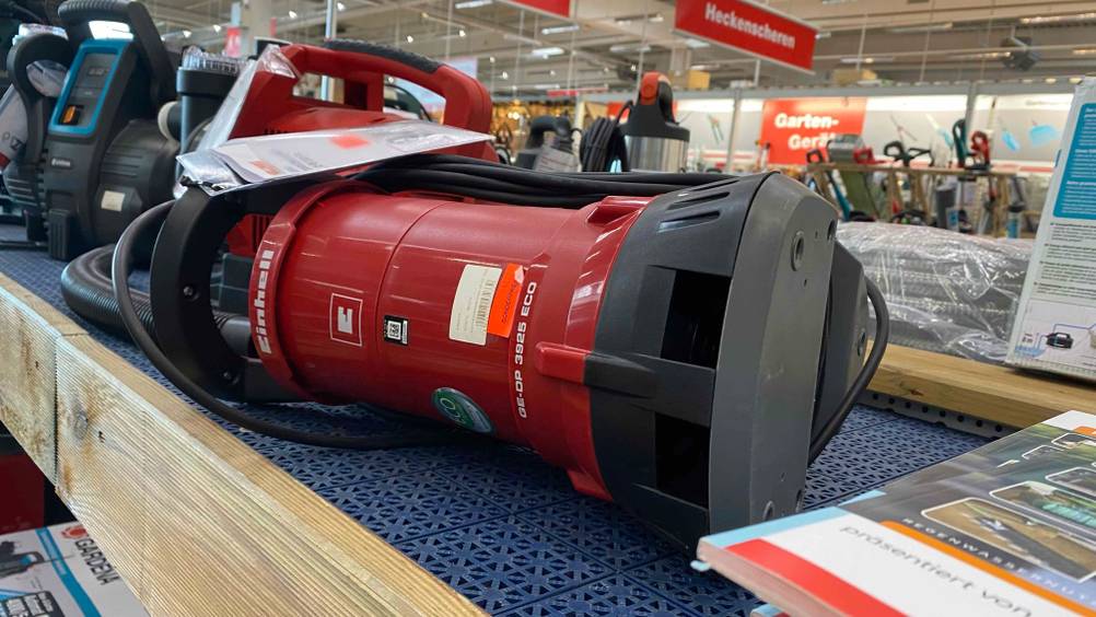 Im Test: Eine auf einem Regal liegende Einhell-Schmutzwasserpumpe von schräg vorne auf einem Verkaufsregal.