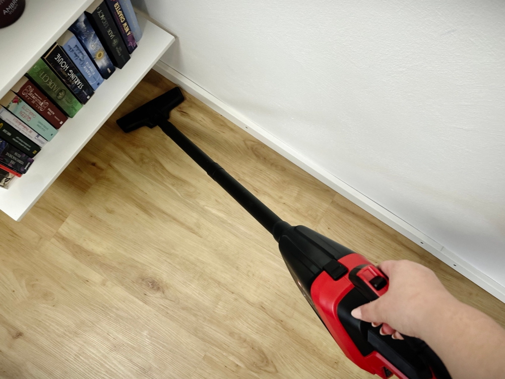 Einhell TE-HV 18/06 mit aufgestecktem Verlängerungsrohr in Benutzung unter einem Bücherregal.