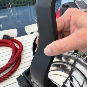 Eine Hand befestigt den Griff des Einhell TE-VC 2025 SACL