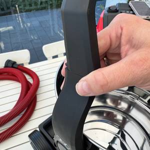 Eine Hand befestigt den Griff des Einhell TE-VC 2025 SACL