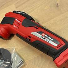 Zu sehen ist der Einhell Varrito mit einem Teil seines beigelegten Zubehörs. Die einzelnen Werkzeuge liegen sichtbar neben dem Gerät.