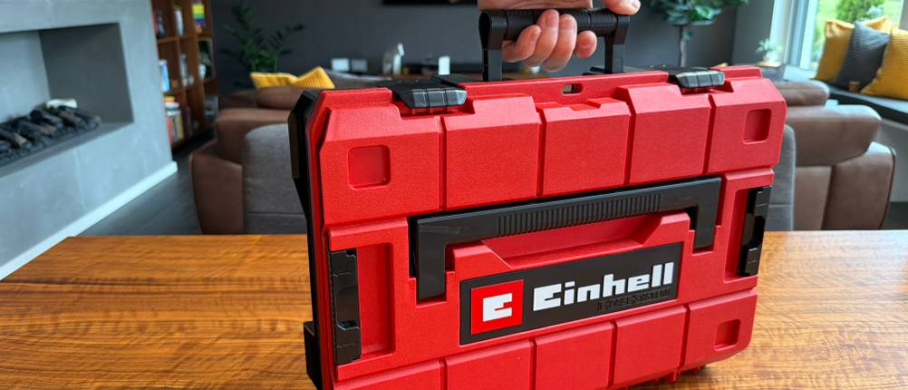Eine Hand hält den Einhell-Werkzeugkoffer am Griff fest
