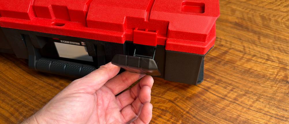 Eine Hand verschließt den Einhell-Werkzeugkoffer