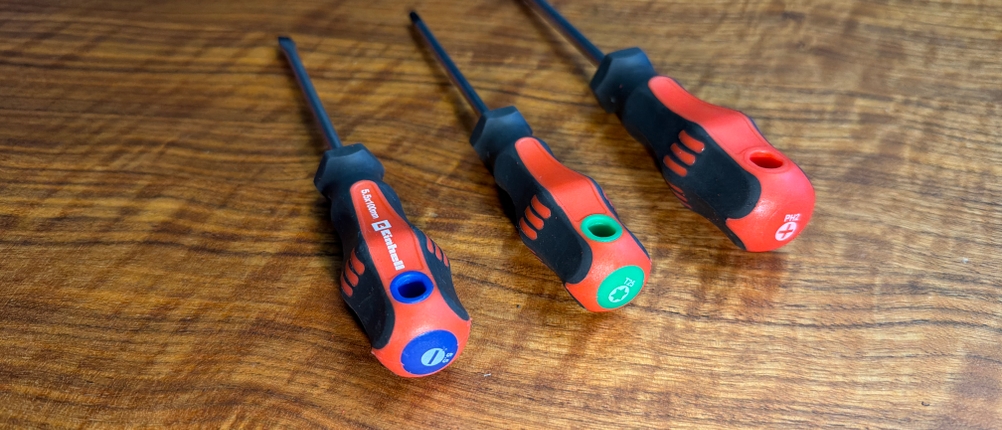 Drei verschiedene Schraubenzieher aus dem Einhell-Werkzeugkoffer liegen auf einem Tisch