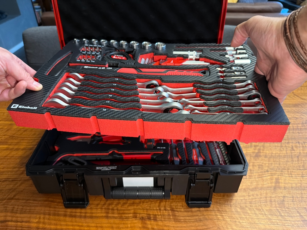 Eine Hand hält einen Einlegeboden aus dem Einhell-Werkzeugkoffer fest