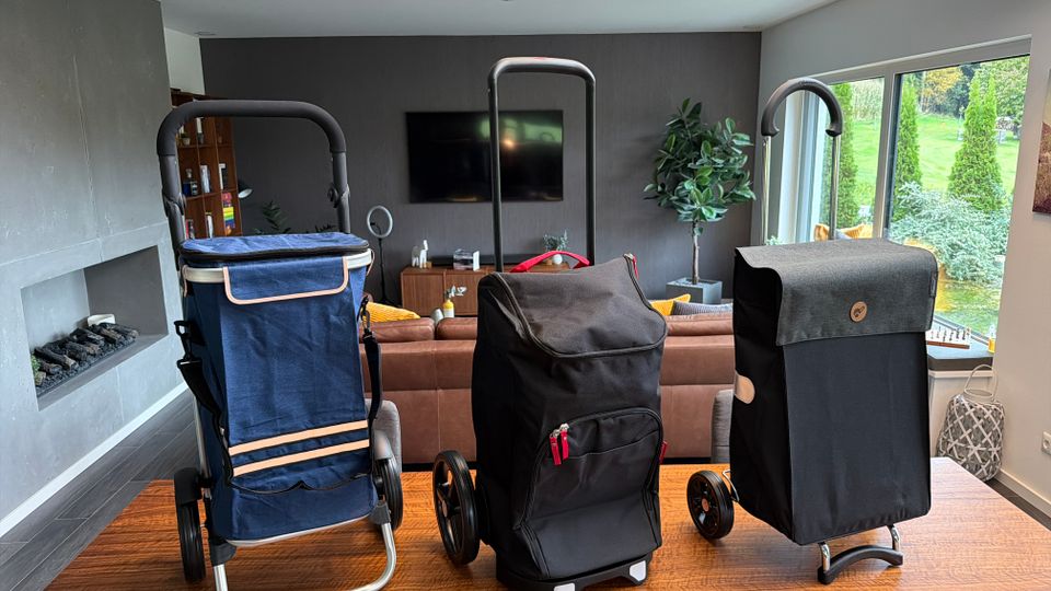 Drei Einkaufstrolleys stehen nebeneinander auf einem Tisch.