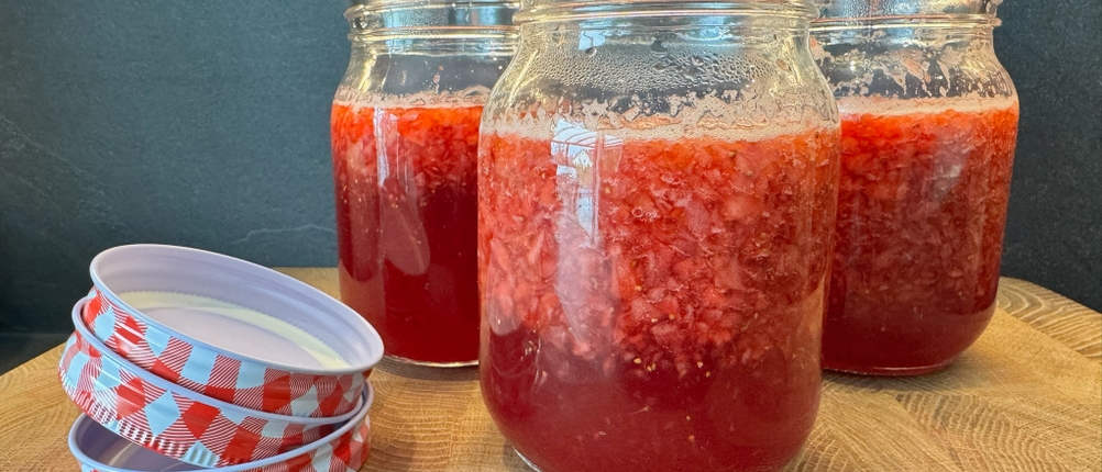 Drei Einmachgläser mit Marmelade stehen auf einem Tisch