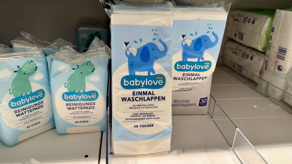 Mehrere Packungen der Einmalwaschlappen im Test in einem Verkaufsregal neben anderen Produkten.