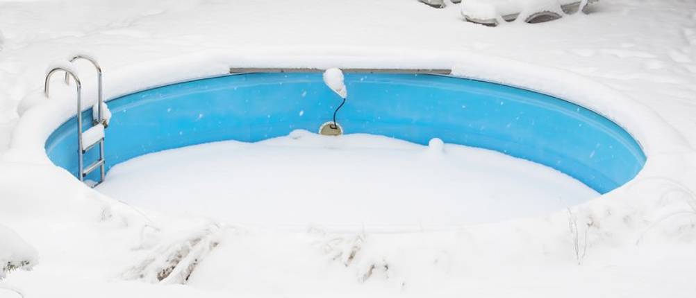 Eisdruckpolster-Test: Ein mit Schnee bedeckter blauer Rundpool.