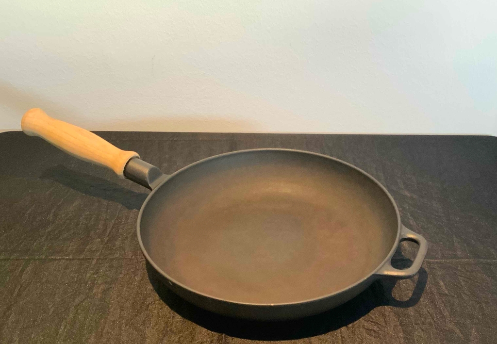 Eisenpfanne getestet: Eine Pfanne vor einer hellen Wand auf einer dunklen Arbeitsfläche.