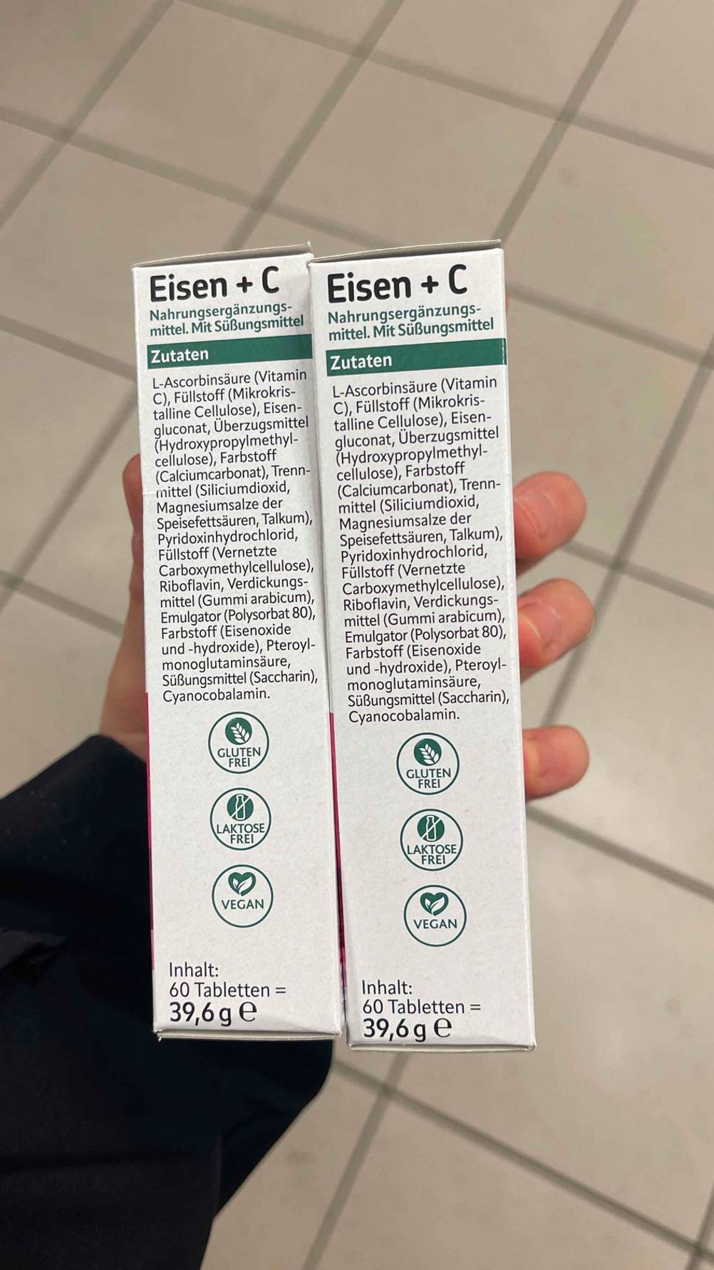 Eine Hand zeigt die Packungsseite von getesteten Eisentabletten mit der Zutatenliste.